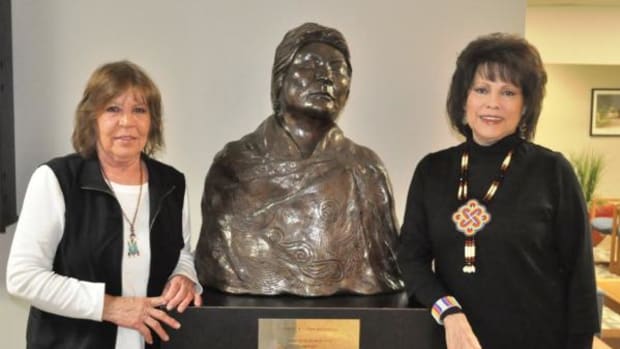(L to R) Cherokee artist Jane Osti and Cherokee Nation Tribal Councilor Victoria Vazquez stand next to the bronze bust of the late Cherokee National Treasure Anna Belle Sixkiller Mitchell. Courtesy Cherokee Nation.