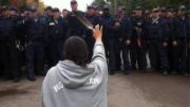 This photo of 28-year-old Amanda Polchies kneeling before Royal Canadian Mounted Police while brandishing an eagle feather during anti-fracking protests in New Brunswick has become iconic as a symbol of resistance to destructive industrial development—and of women's role in fighting for the water.