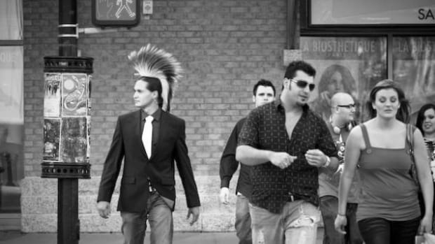 Jacob Pratt walks the city streets wearing a jacket, tie and roach in a photo from Nadya Kwandibens' 'Concrete Indians' series