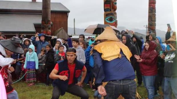 Hydaburg residents dance on July 24 to celebrate two new totem poles that were erected in the village's newly restored totem park, led by T.J. Young, a prominent young Haida carver.