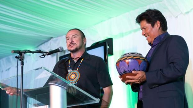 Notah Begay III, right, holds the traditional Native pottery awarded to Keith Anderson, Shakopee Mdewakanton Sioux Community vice chairman, speaking, for his ongoing investment in addressing the public health concerns facing Native Americans. Anderson was honored with the second annual Oneida Indian Nation Health Champion for Native Children Award.