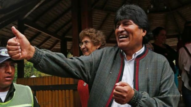 Bolivia's President Evo Morales gives a thumbs up to people at a trout farm where he stopped to eat in Paracti, Bolivia, Saturday, Oct. 11, 2014. Morales stopped here to eat as he traveled to the city where he'll vote in tomorrow's general election. Morales is running for a third term in Sunday's presidential elections.