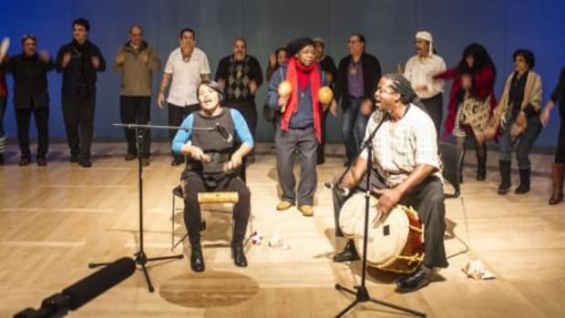 Irka Mateo and James Lovell are at the microphones while others dance at the Taino Identity Beyond Columbus event held at NMAI on December 14.