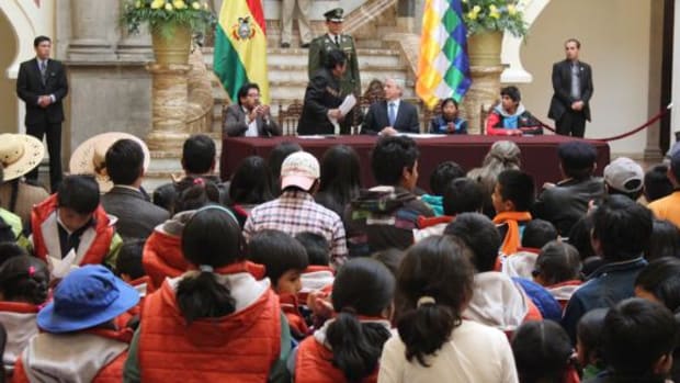 Eddy Roman Davalos Cayo, 15 Vice President of the Union of Child and Adolescent Workers, and children sit with Bolivian vice president Alvaro Garcia Linera and other leaders at the signing of the new Boys, Girls and Adolecents' code on July 17, 2014.