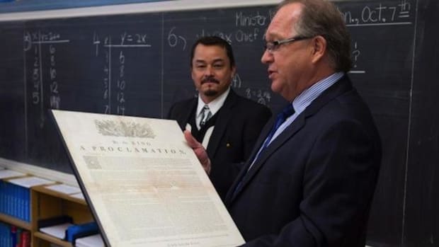 Aboriginal Affairs Minister Bernard Valcourt, right, and Assembly of First Nations National Chief Shawn A-in-chut Atleo visit a seventh-grade classroom in October 2013 just before the federal government released a draft of education reform legislation. Valcourt is holding a copy of the Royal Proclamation, which celebrated its 250th anniversary this year.