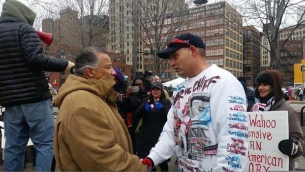 Robert Roche, left, and Cleveland Indians fan Pedro Rodriguez meet again during opening day on Monday outside Progressive Field in Cleveland, Ohio. Rodriguez was photographed two years ago wearing red face, berating Roche for protesting the team's name and mascot, Chief Wahoo.