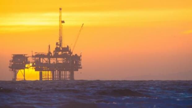 The sun sets on an offshore oil rig.