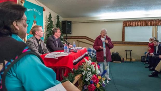 Sharon No Heart, center, addresses a crowd at the He Sapa New hope Church in Rapid City, South Dakota, on Monday. Residents had gathered to discuss recent racially motivated incidents in the city.