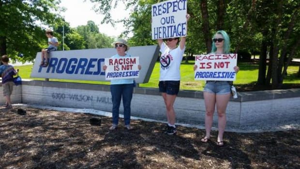 From left, Sue Collyer, Bee Schrull, Rachael Collyer protest outside of Progressive Insurance headquarters in Mayfield, Ohio.