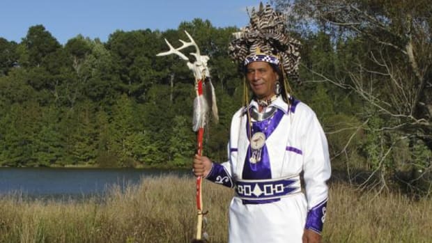 Principal Chief Wayne Mackanear Brown on Meherrin tribal land. The three figures at the lower edge of the chief's regalia represent the Tuscarora, Meherrin, and Nottoway peoples—nations of the Southern Iroquois Confederacy.