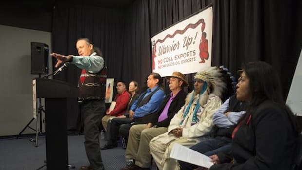 Otto Braided Hair of the Northern Cheyenne Tribe speaks at a gathering of leaders and members of nine Pacific Northwest tribes, on both sides of the U.S.–Canada border, asking the U.S. Army Corps of Engineers to reject a coal-rail terminal at Cherry Point. They were also protesting rail transport of other fossil fuels, such as oil, especially from the carbon-footprint-enhancing Alberta oil sands in Canada.