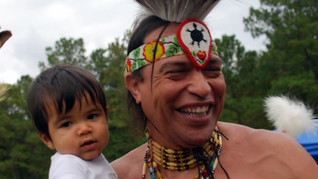 Pictured: Native American father in regalia holds child; ICWA