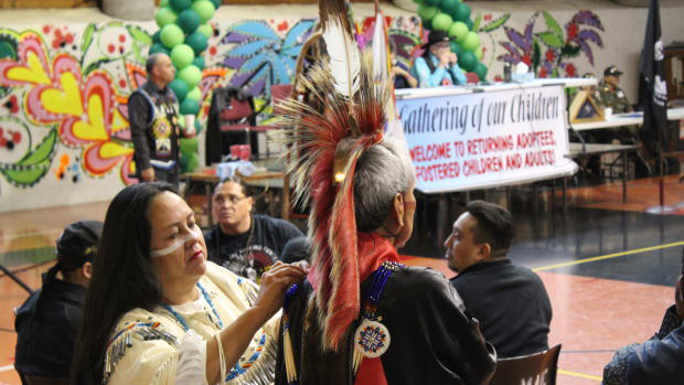 Larry Brown (Navajo) prepares for the November powwow ceremony at the Minneapolis American Indian Center. The ceremony provides a space for American Indian families to heal after decades of family separation. Photo: Camille Erickson.