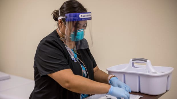 In this Tuesday, Dec. 29, 2020, photo provided by Johns Hopkins Center for American Indian Health, registered nurse Starla Garcia prepares a coronavirus vaccine in Chinle, Ariz., for someone who enrolled in the COVID-19 vaccine trials on the Navajo Nation and initially received a placebo. (Nina Mayer Ritchie/Johns Hopkins Center for American Indian Health via AP)