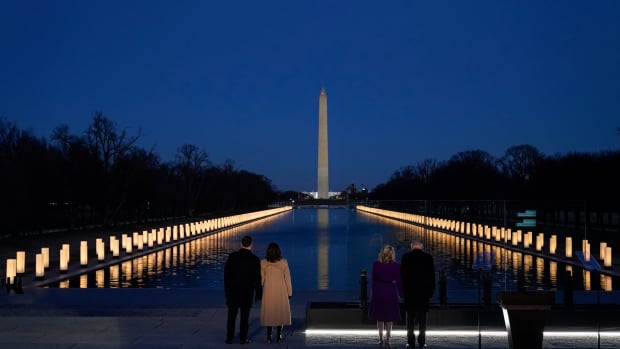 President-elect Joe Biden and his wife Jill, along with Vice President-elect Kamala Harris and her husband Doug Emhoff stand during a COVID-19 memorial, and look at lights placed around the Lincoln Memorial Reflecting Pool, Tuesday, Jan. 19, 2021, in Washington. (AP Photo/Alex Brandon)
