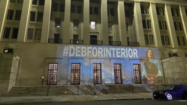 IllumiNative and Native Organizers Alliance project Rep. Deb Haaland on the US Department of Interior building in Washington, D.C. the night before her confirmation hearing.