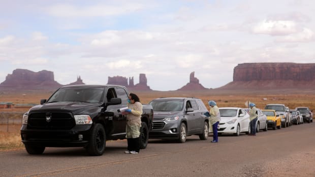 Korene Atene, a certified nursing assistant with the Monument Valley Health Center, gets information from people lined up to get tested for COVID-19 outside of the center in Oljato-Monument Valley, San Juan County, on Thursday, April 16, 2020. The Navajo Nation has one of the highest per capita COVID-19 infection rates in the country. (Photo by Kristin Murphy, Deseret News via AP)