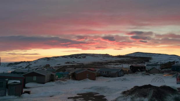 In this May 7, 2020 photo provided by Aaron Watson, the sun sets over Iqaluit, the capital of Nunavut territory in far north Canada. Iqaluit has a population of about 7,000 people, many of whom are Inuit. Watson says, so far, there are no cases of coronavirus in the town. (AP Photo via Aaron Watson)