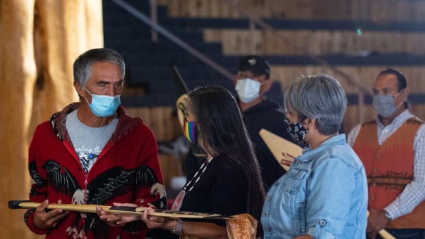 Steve Solomon of the Lummi Nation presents Shelly Boyd, middle, and the Confederated Tribes of the Colville Reservation with a gift of alliance between their Tribal Nations. Joined by her daughter Stevey Seymour, right, the members of the Sinixt/Arrow Lake band of the Confederated Tribes of the Colville Reservation spoke at the Indigenous Peoples Day celebration hosted by the Children of the Setting Sun Productions at the Wex'liem Community Building in Lummi Nation near Bellingham, Wash., Monday, Oct. 11, 2021. The event, streamed via Zoom and Facebook, highlighted the contributions and diverse cultures of Indigenous peoples as well as the need for climate action. (Photo by The Bellingham Herald)