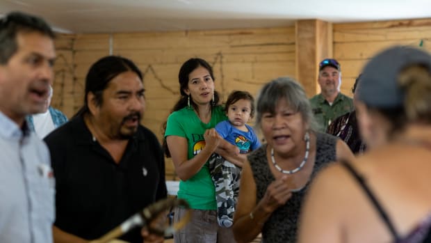 Natasha Singh, Koyukon Athabascan, dances to the Stevens Village drummers with her youngest son, Isaac, during an inter-tribal meeting about community wellness.
