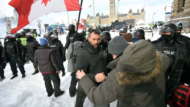 Police move in to clear downtown Ottawa near Parliament Hill on Saturday, Feb. 19, 2022. Police resumed pushing back protesters on Saturday after arresting more than 100 and towing away vehicles in Canada’s besieged capital, and scores of trucks left under the pressure, raising authorities’ hopes for an end to the three-week protest against the country’s COVID-19 restrictions. (Justin Tang /The Canadian Press via AP)