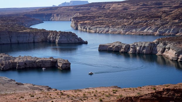 In this July 31, 2021 photo, a boat cruises along Lake Powell near Page, Ariz. The elevation of Lake Powell fell below 3,525 feet (1,075 meters), a record low that surpasses a critical threshold at which officials have long warned signals their ability to general hydropower is in jeopardy. (AP Photo/Rick Bowmer, File)