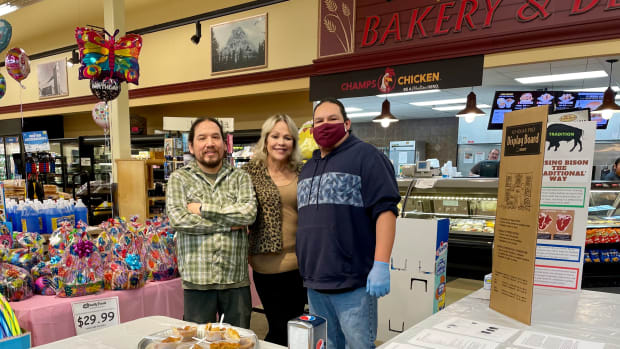 Loren Racine, grocery manager, Dori Goss, general manager, and Otis Talks Different, meat department manager, smile as they celebrate the sale of Blackfeet bison at Glacier Family Foods. (Nora Mabie/Great Falls Tribune)