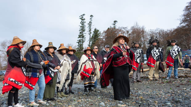 Raynell Morris, an enrolled Lummi Tribal citizen and vice president of the Sacred Lands Conservancy, leads the Bob Family singers in a prayer for the repatriation of southern resident orca Sk’aliCh’elh-tenaut — who has lived and performed at the Miami Seaquarium for over 50 years — to her home waters of the Salish Sea at a gathering Sunday, March 20, 2022, at the sacred site of Cherry Point in Whatcom County, Wash. (Photo by The Bellingham Herald)