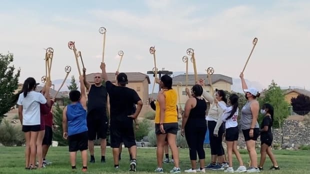 The Running Medicine program includes a session of Ojibwe stickball in July 2021, with participants raising their sticks high to begin. The program, founded by  Anthony and Shannon Fleg in Albuquerque, New Mexico, helps Indigenous and non-Native communities benefit from healthy activities. (Photo courtesy of Rosalita Whitehair)