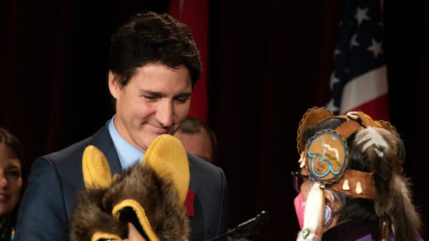 Prime Minister Justin Trudeau is gifted a pair of traditional moccasins and mittens by Assembly of First Nations National Chief, RoseAnne Archibald during the Assembly of First Nations Special Chiefs Assembly in Ottawa, Ontario, Canada, on Thursday, Dec. 8, 2022. The assembly passed a motion that will create a new regional chief to represent Newfoundland, which has a growing Mi'kmaq population. (Spencer Colby/The Canadian Press via AP)
