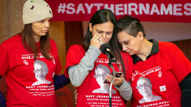 Gerry Davis, supported by sisters Sara, left, and Nona Blouin, reads a statement asking for help in the search for their missing sister, Mary Ellen Johnson-Davis, during a gathering marking two years since her disappearance in Snohomish County on Sunday, Dec. 11, 2022, at Daybreak Star Indian Cultural Center in Seattle, Washington. (Ryan Berry / The Herald)