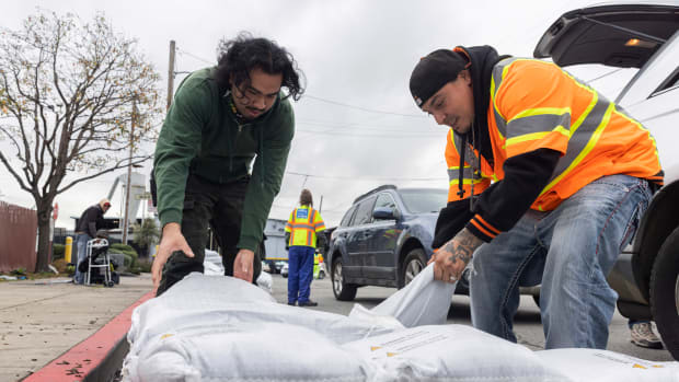 Fernando Bizarro, left, collects sandbags from an emergency distribution center to prepare for an upcoming storm, Tuesday, Jan. 3, 2023, in San Francisco. (Santiago Mejia/San Francisco Chronicle via AP)