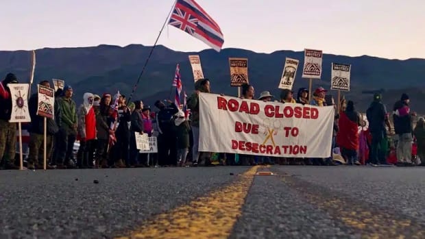 FILE - Demonstrators block a road at the base of Hawaii's tallest mountain, in Mauna Kea, Hawaii, on July 15, 2019, to protest the construction of a giant telescope on land that some Native Hawaiians consider sacred. Hawaii's new attorney general said Tuesday, Jan. 10, 2023, that several dozen elders won't be subject to another round of prosecution for blocking a road three years ago to prevent the construction of the new telescope. (AP Photo/Caleb Jones, File)