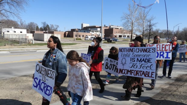 Tyler LaMere and Marilyn Purscell lead a group of Winnebago Two Spirits and allies on a march from the tribal court building to the tribal council meeting April 18, 2022. Joining them are (left to right): Trisha Estringer, Marilyn Free LaMere, Ariah Walker, Willy Bass, Rev. Isiah Broken Leg and Elaine Rice. (Photo by Tim Trudell for the Flatwater Free Press)