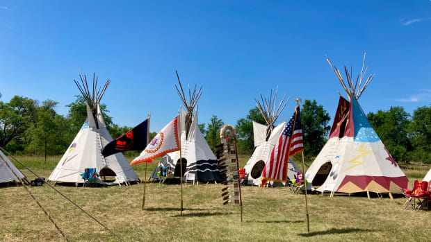 Members of the Chauncey Eagle Horn/Phillip Iyotte American Legion opened the ceremony in Rosebud by posting an eagle feather staff, the Rosebud Sioux Tribe flag, the POW flag and the U.S. flag in front of the nine teepees erected to honor the children and their families on July 14, 2022. (Photo by Vi Waln, ICT)