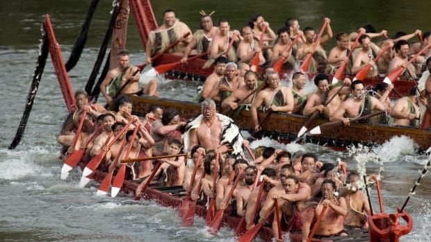 Paddlers aboard three Maori waka canoes prepare to salute the King Tuheitia and others on the Waikato River during celebrations on Aug. 21, 2007, for the first anniversary of the coronation of the king at Turangawaewae Marae in Ngaruawahia, New Zealand. At the annual celebration on Aug. 20, 2022, the king called for politicians to stop using Maori issues for political gain. (AP Photo/NZPA, Stephen Barker)