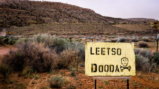A sign with a skull and crossbones that translates as ‘No uranium’ in the Diné language warns visitors near the Church Rock mining site in Navajo Nation. (Photo by Eli Cahan)