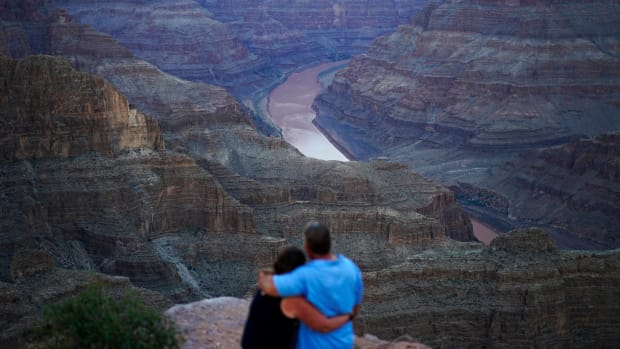 Alyssa Chubbuck, left, and Dan Bennett embrace while watching the sunset at Guano Point overlooking the Colorado River on the Hualapai reservation Monday, Aug. 15, 2022, in northwestern Arizona. In November 1922, seven land-owning white men brokered a deal to allocate water from the Colorado River, which winds through the West and ends in Mexico. During the past two decades, pressure has intensified on the river as the driest 22-year stretch in the past 1,200 years has gripped the southwestern U.S. (AP Photo/John Locher)