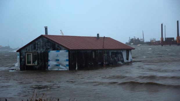 A home is seen floating in the Snake River near Nome, Alaska, on Saturday, Sept. 17, 2022. Much of Alaska's western coast saw flooding and high winds as the remnants of Typhoon Merbok moved into the Bering Sea region. The National Weather Service says some locations could experience the worst coastal flooding in 50 years. (AP Photo/Peggy Fagerstrom)