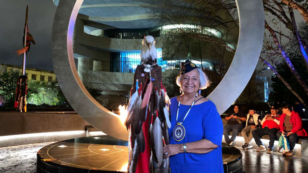Linda Woods, Grand Traverse Band of Ottawa and Chippewa Indians, stands with her eagle staff in front of the National Native American Veterans Memorial in Washington, D.C. on Veteran's Day on November 11, 2022. (Jourdan Bennett-Begaye/ICT)