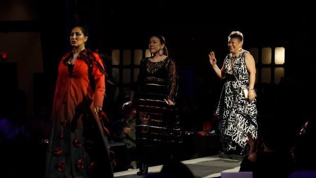 Delina White and her daughter Sage Davis walk the runway at Quincy Hall April 25 at the Native Nations Fashion Night after showing the Restorative Apparel Co-Design Collection. The designs represent relationships, connection to the land, community, spirituality, identity, healing and sustainability, using primarily upcycled and natural materials. (Bella Haveman, special to ICT)