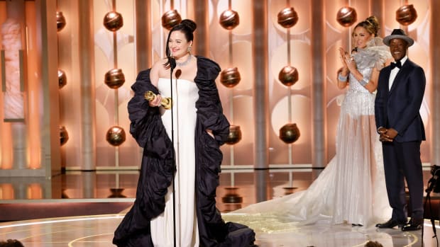 This image released by CBS shows Lily Gladstone, left, as she accepts the award for best female actor in motion picture - drama for her role in "Killers of the Flower Moon" during the 81st Annual Golden Globe Awards in Beverly Hills, Calif., on Sunday, Jan. 7, 2024. Looking on at right are presenters Kate Beckinsale and Don Cheadle. (Sonja Flemming/CBS via AP)   