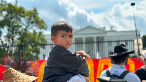 A young boy looks back at a demonstrator yelling "Free Leonard Peltier" during the Free Leonard Peltier 79th Birthday Action in front of the White House in Washington, D.C. on September 12, 2023. Peltier has been incarcerated for nearly 50 years. (Pauly Denetclaw, ICT)