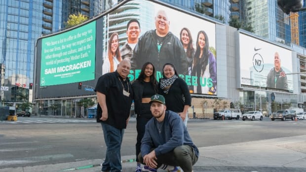 Sam McCracken, a citizen of the Sioux and Assiniboine Tribes, at left, made a proposal to Nike in 1997 that grew into the Nike Air Native N7 shoe and retail line. He is now general manager and founder of Nike's N7 division. He is shown here outside Staples Center in Los Angeles with Madison Hammond, center, a Navajo/San Felipe Pueblo professional soccer player and a Nike N7 ambassador, and Nike employees Mitzi Yonezawa, rear right, and Kristian Grobecker, kneeling. (Photo by John Jefferson IV, courtesy of Nike)