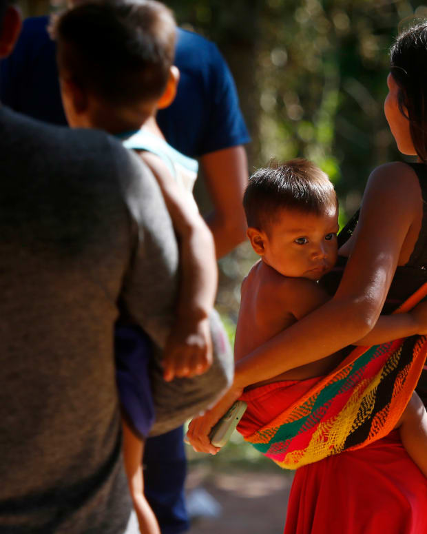 A Yanomami woman carries a toddler on the property of the Saude Indigenous House, a center responsible for supporting and assisting Indigenous people in Boa Vista, Roraima state, Brazil, Wednesday, Jan. 25, 2023. The government declared a public health emergency for the Yanomami people in the Amazon, who are suffering from malnutrition and diseases such as malaria. (AP Photo/Edmar Barros)
