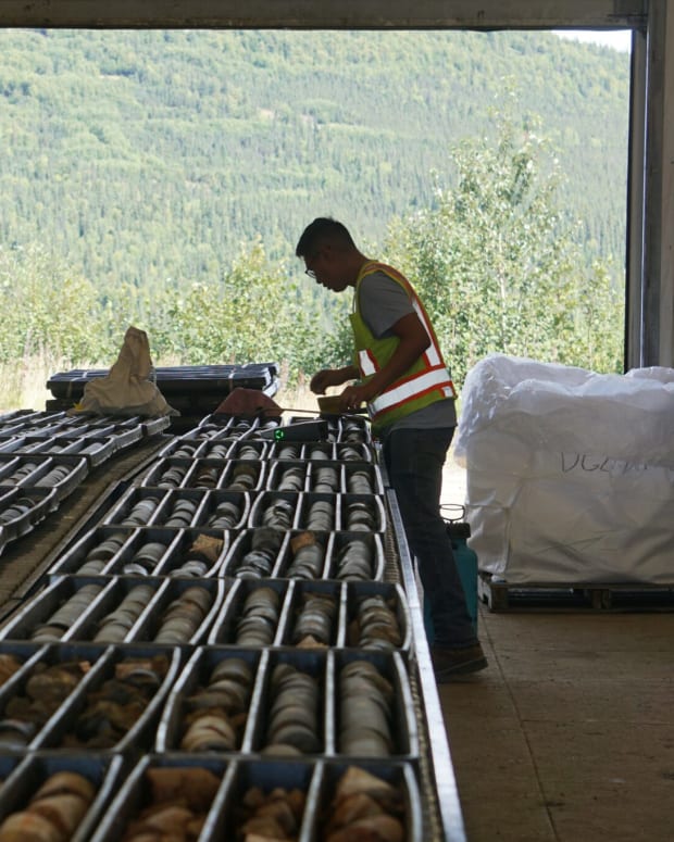 Mine worker Justin Andrew examines and core samples at the Donlin mine camp on Aug. 11. Outside is the hillside that would be dug for its gold if the huge mine is developed. (Photo by Yereth Rosen/Alaska Beacon)
