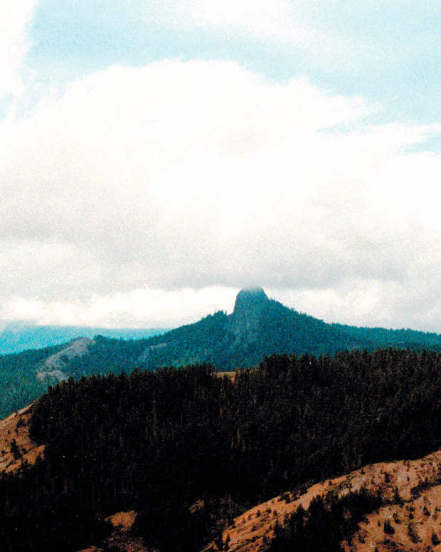 FILE- In this July 6, 2000, file photo, Pilot Rock rises into the clouds in the Cascade-Siskiyou National Monument near Lincoln, Ore. After touring the "unique" Cascade-Siskiyou National Monument in Oregon and speaking to ranchers, loggers and environmentalists, U.S. Interior Secretary Ryan Zinke must next make a recommendation on whether it should be abolished or resized. (AP Photo/Jeff Barnard, File)   