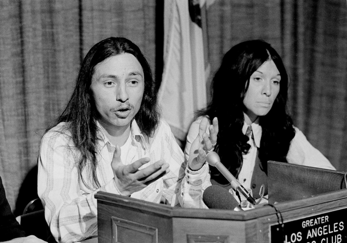 FILE - This March 7, 1975, file photo shows John Trudell, left, national chairman of the American Indian Movement, AIM, flanked by singer Buffy St. Marie during a news conference in Los Angeles. Trudell, a poet and actor who spoke for American Indian protesters during the 1969 Alcatraz Island occupation and later headed the American Indian Movement, has died at age 69. A trustee of Trudell's estate, Cree Miller, says he died of cancer on Tuesday, Dec. 8, 2015, at his home in Santa Clara County in Northern California. (AP Photo/Wally Fong, File)