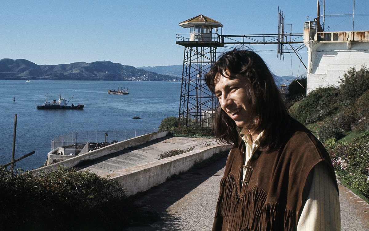 FILE - In this Dec. 1, 1969, file photo, John Trudell poses for a photo on steps leading to prison atop Alcatraz in San Francisco. Trudell, a poet and actor who spoke for American Indian protesters during the 1969 Alcatraz Island occupation and later headed the American Indian Movement, has died at age 69. A trustee of Trudell's estate, Cree Miller, says he died of cancer on Tuesday, Dec. 8, 2015, at his home in Santa Clara County in Northern California. (AP Photo, File)