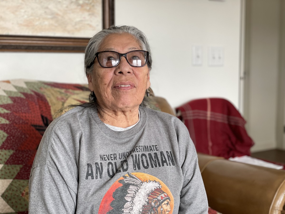 Madonna Thunder Hawk, 83, shown here in early February 2023, was one of the four women medics during the occupation of Wounded Knee, which started on Feb. 27, 1973 and ended May 8, 1973. She wears her “Never underestimate an old woman” shirt proudly. (Photo by Kalle Benallie/ICT)